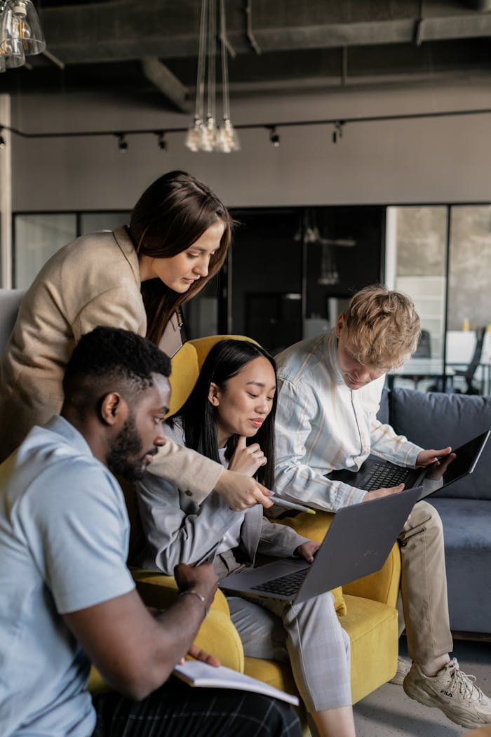 Photo of Coworkers Looking at a Laptop